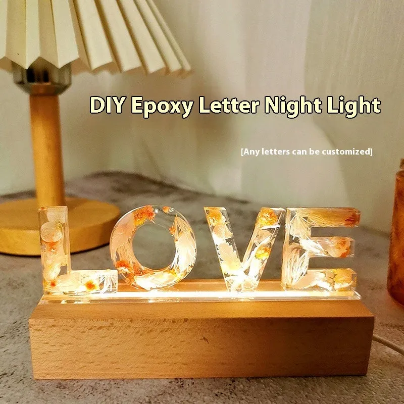 Letter small night lamp with dried flowers, blue colour, warm light, on a table