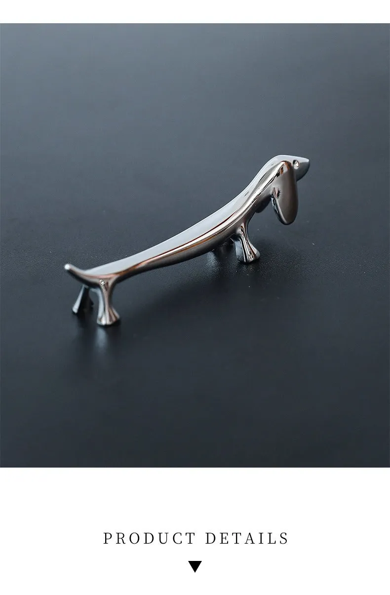 Silver zinc alloy sausage dog chopstick rest knife holder on desk with pen and chopsticks