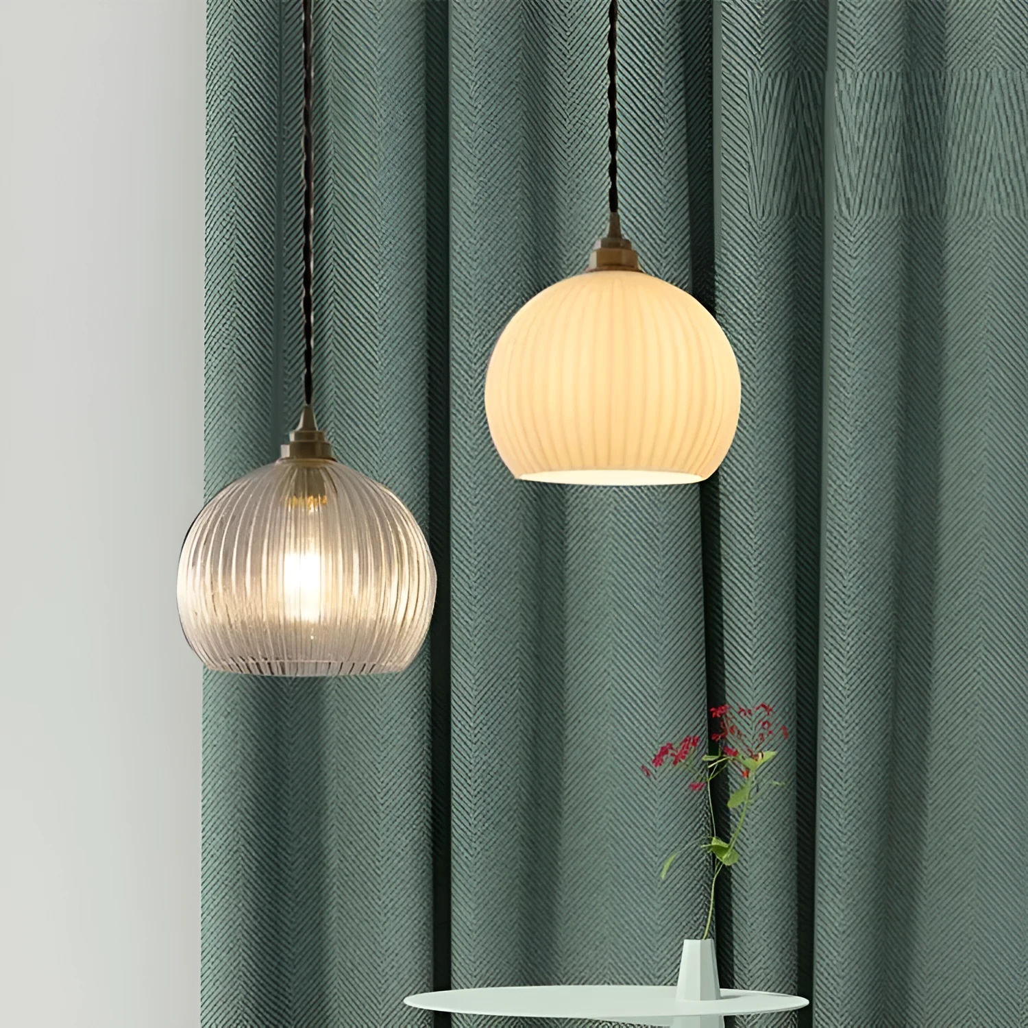 Minimal single head pendant lamp with copper body and transparent glass shade on a dark background