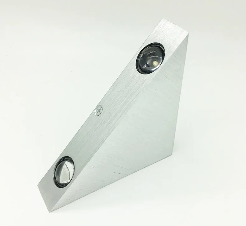 Set of three white LED wall lights with dual heads mounted on a wall showing warm white light