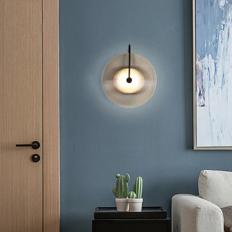 Round glass wall lamp in gold finish mounted on a wall with iron body and clear glass lampshade
