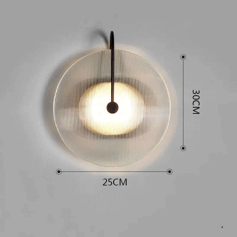 Round glass wall lamp in gold finish mounted on a wall with iron body and clear glass lampshade