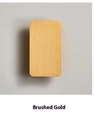 Minimalist black nordic wall lamp mounted beside a bed, emitting warm white light.