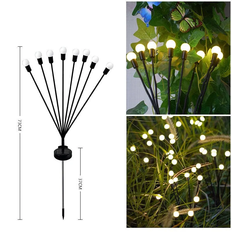 Solar-powered LED firefly garden spike light with multiple heads and a press-in ground plug on grass.