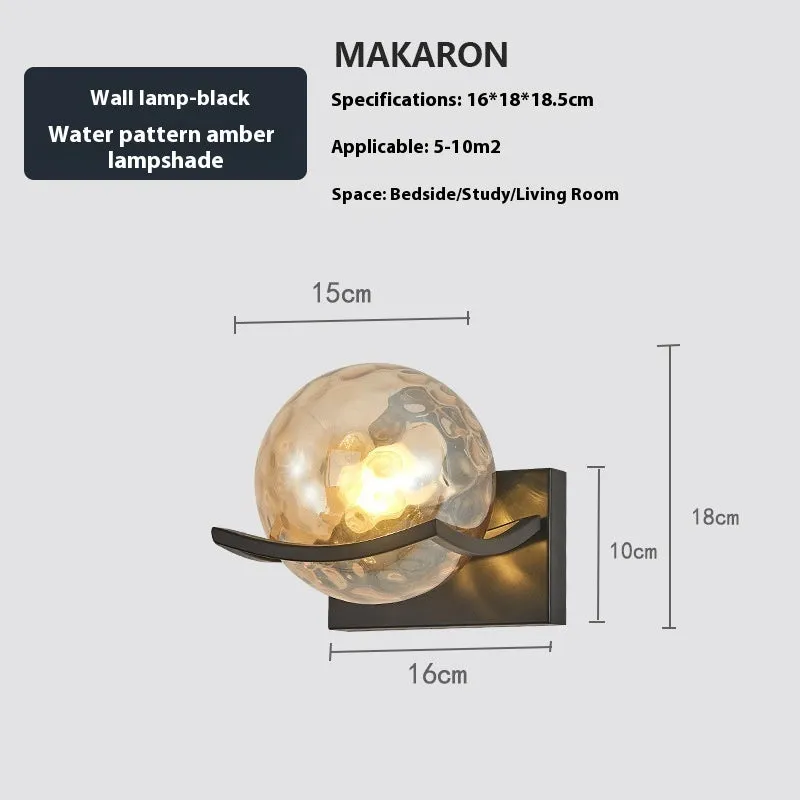 Modern minimalist black wall lamp with striped clear cover mounted beside a bed