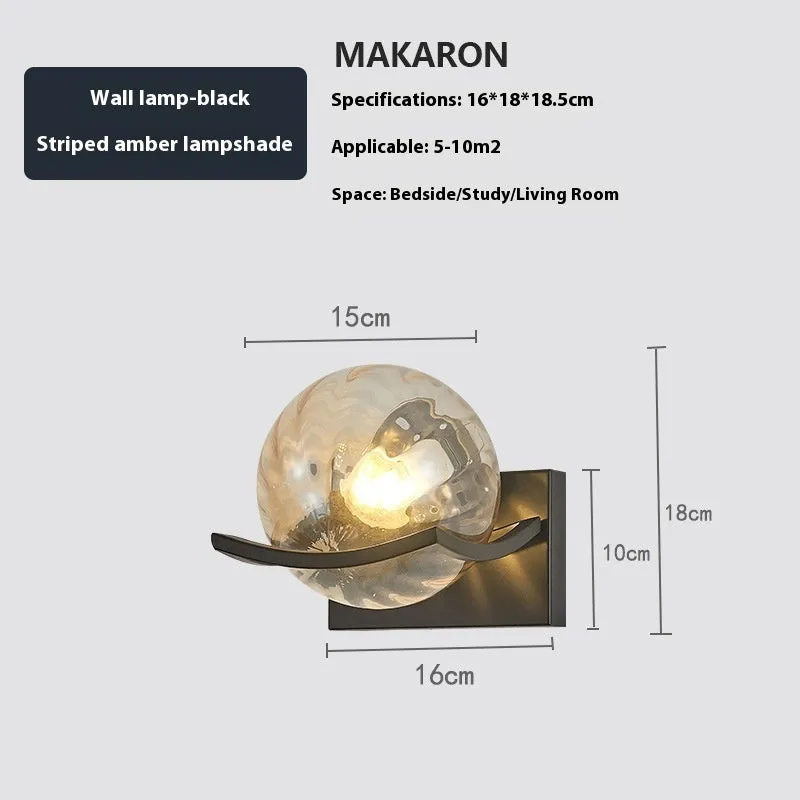 Modern minimalist black wall lamp with striped clear cover mounted beside a bed