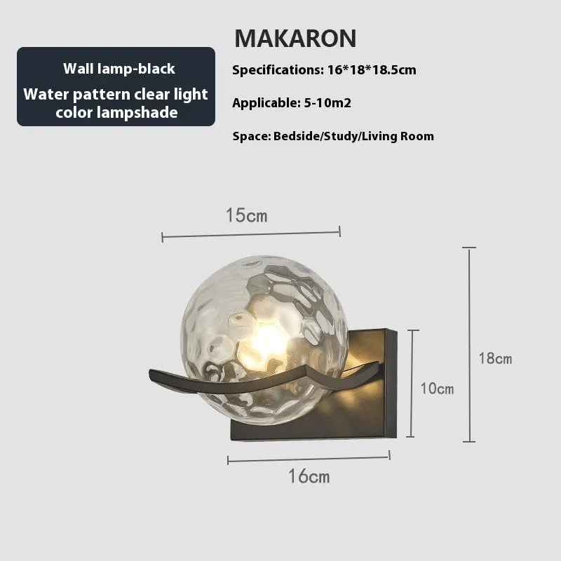Modern minimalist black wall lamp with striped clear cover mounted beside a bed