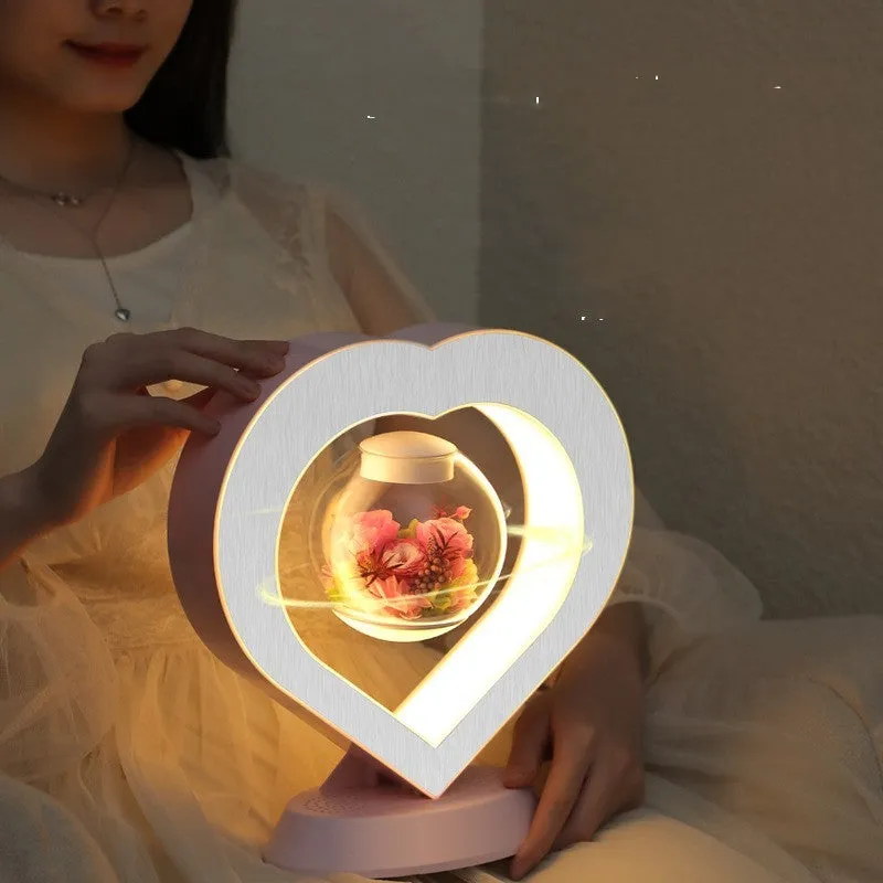 Magnetic levitation lamp with pink eternal rose inside transparent sphere and Bluetooth speaker on USB base