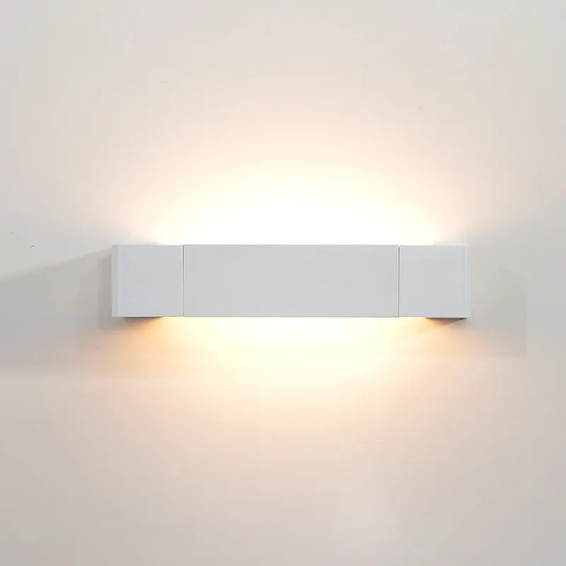 Modern minimalist wall lamp with aluminium shade in gold finish against a white wall