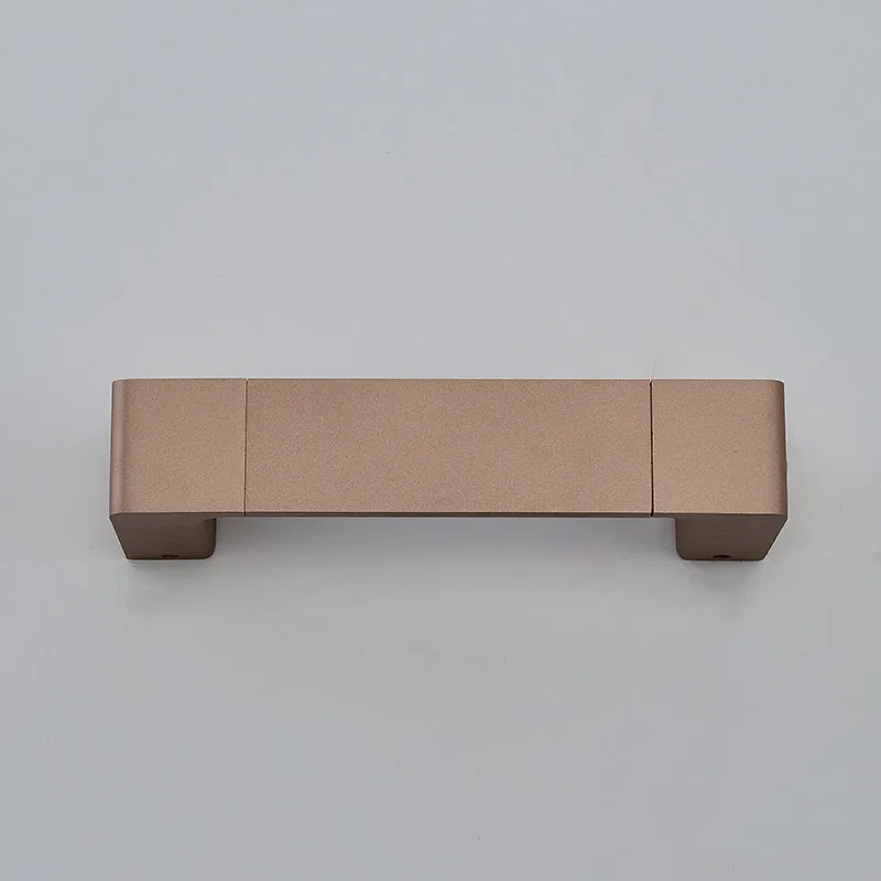 Modern minimalist wall lamp with aluminium shade in gold finish against a white wall