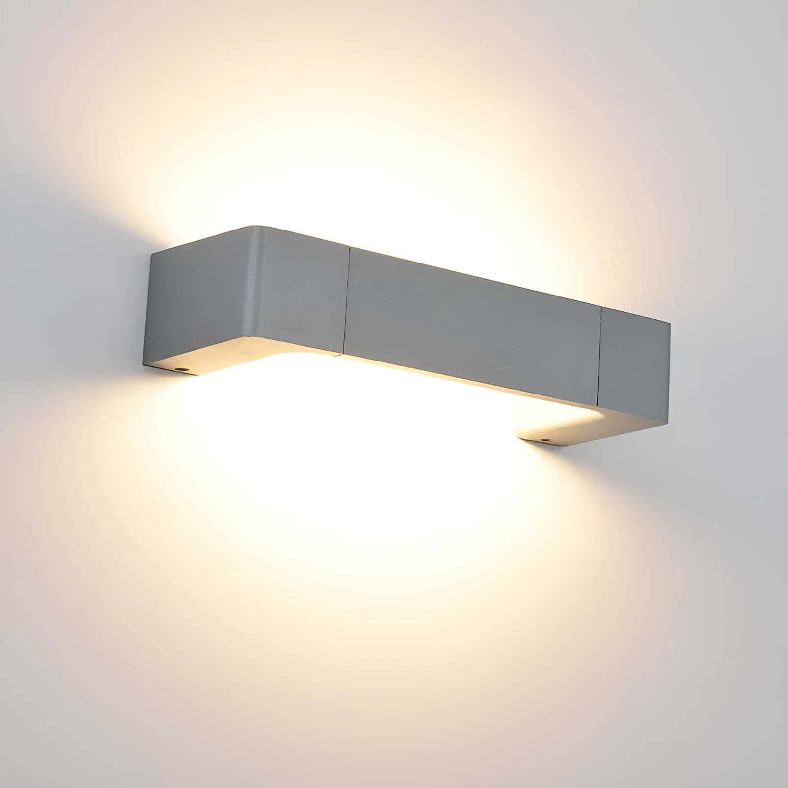 Modern minimalist wall lamp with aluminium shade in gold finish against a white wall
