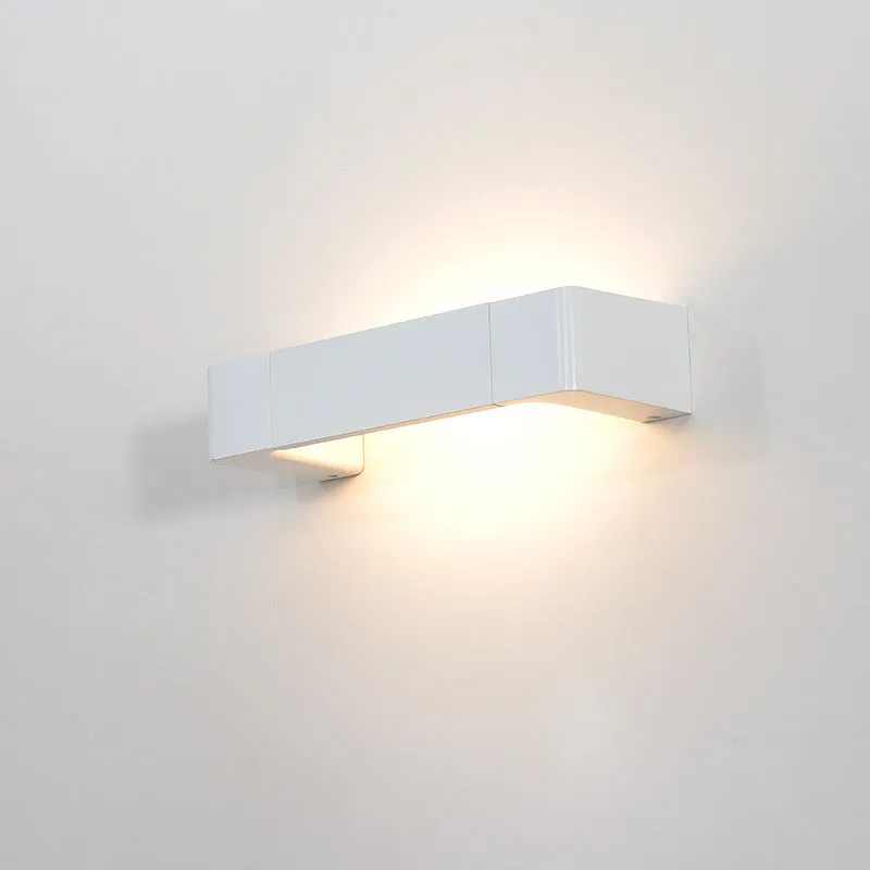 Modern minimalist wall lamp with aluminium shade in gold finish against a white wall