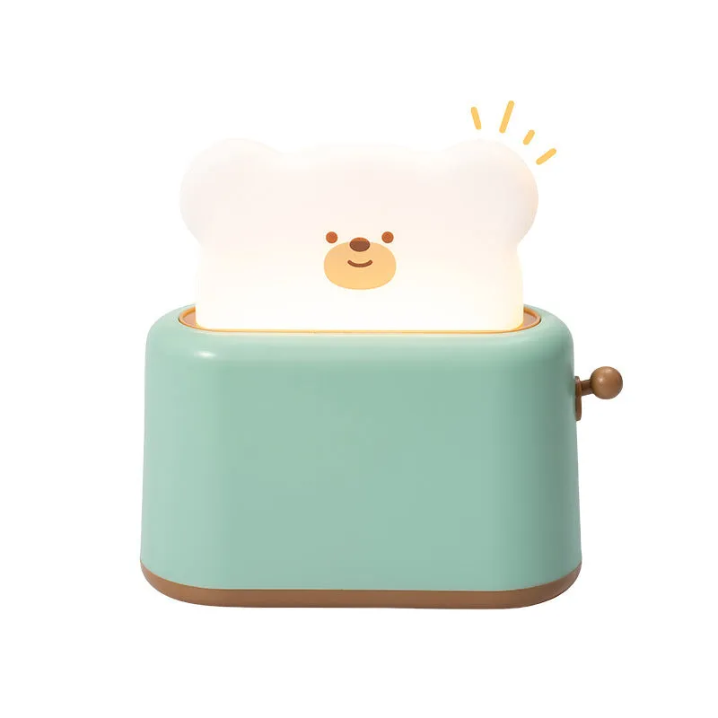 Bread bear shaped silicone night light with warm yellow glow on a desk