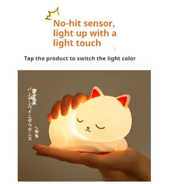 Sleepy cat shaped silicone induction night light with white glow on table