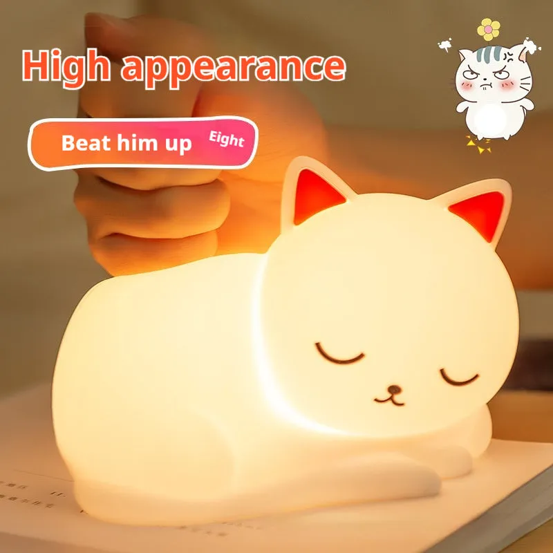 Sleepy cat shaped silicone induction night light with white glow on table