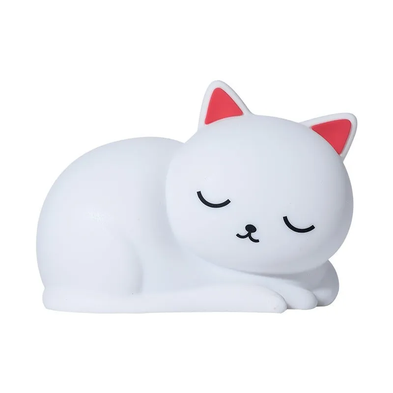 Sleepy cat shaped silicone induction night light with white glow on table
