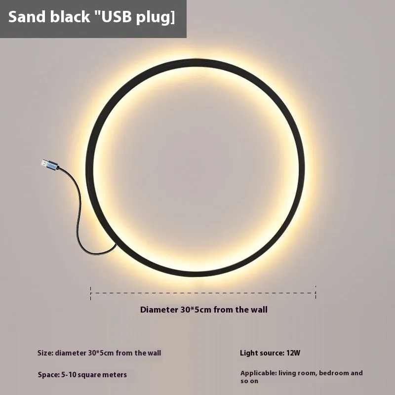 Minimalist black ring wall lamp with acrylic shade mounted on a bedroom wall