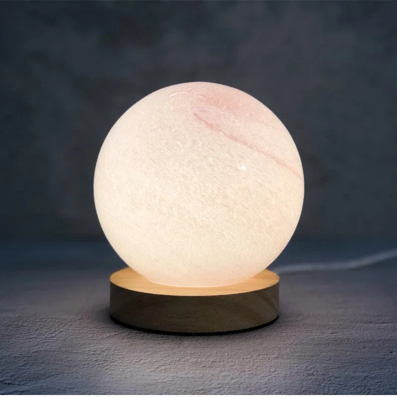 Nordic style Planet Light table lamp with transparent glass shade, shown in emerald green colour.