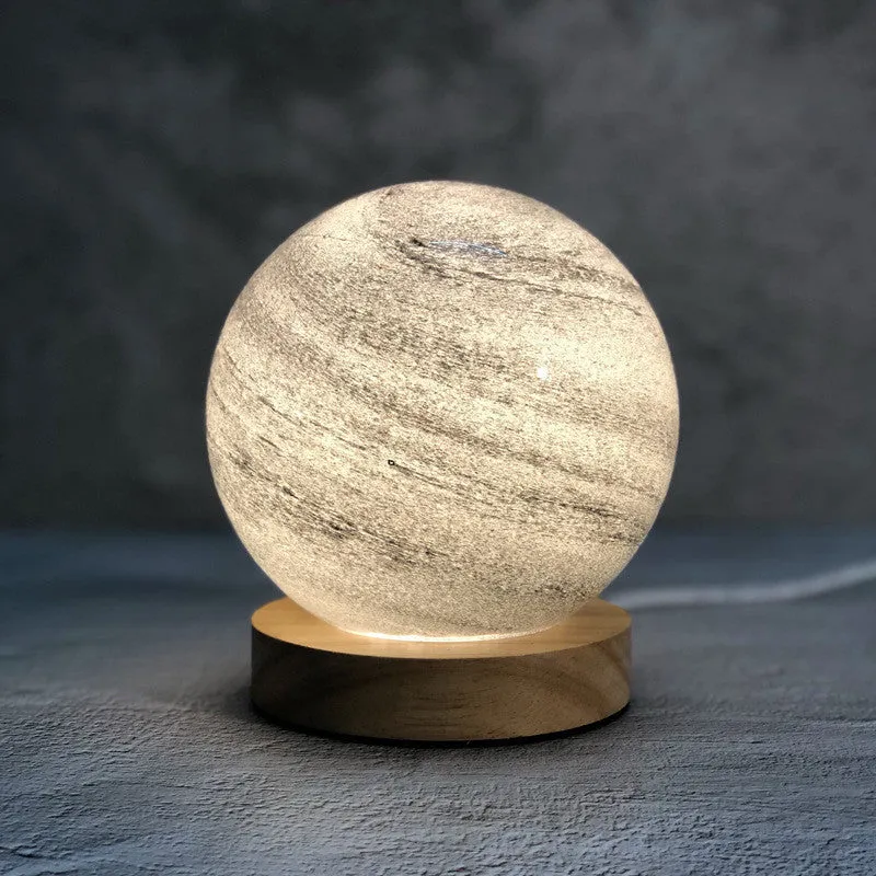 Nordic style Planet Light table lamp with transparent glass shade, shown in emerald green colour.