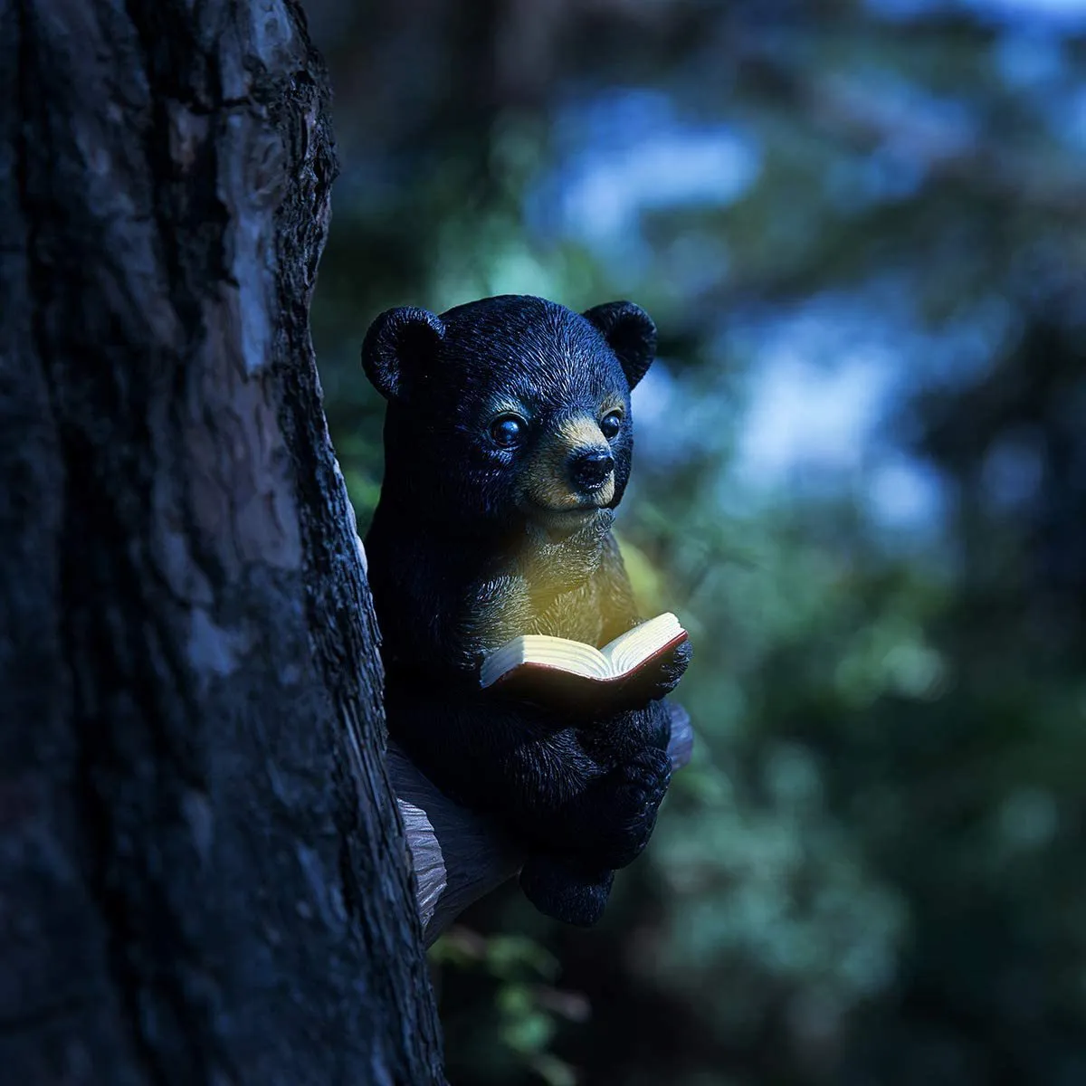 Black bear solar light ornament in synthetic resin placed in garden with solar panel on top