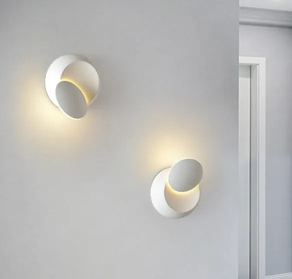 Rotating lunar eclipse LED wall lamp with aluminium shade in black finish on a living room wall