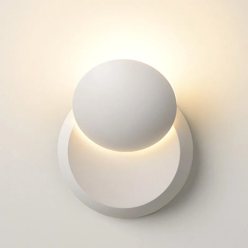 Rotating lunar eclipse LED wall lamp with aluminium shade in black finish on a living room wall