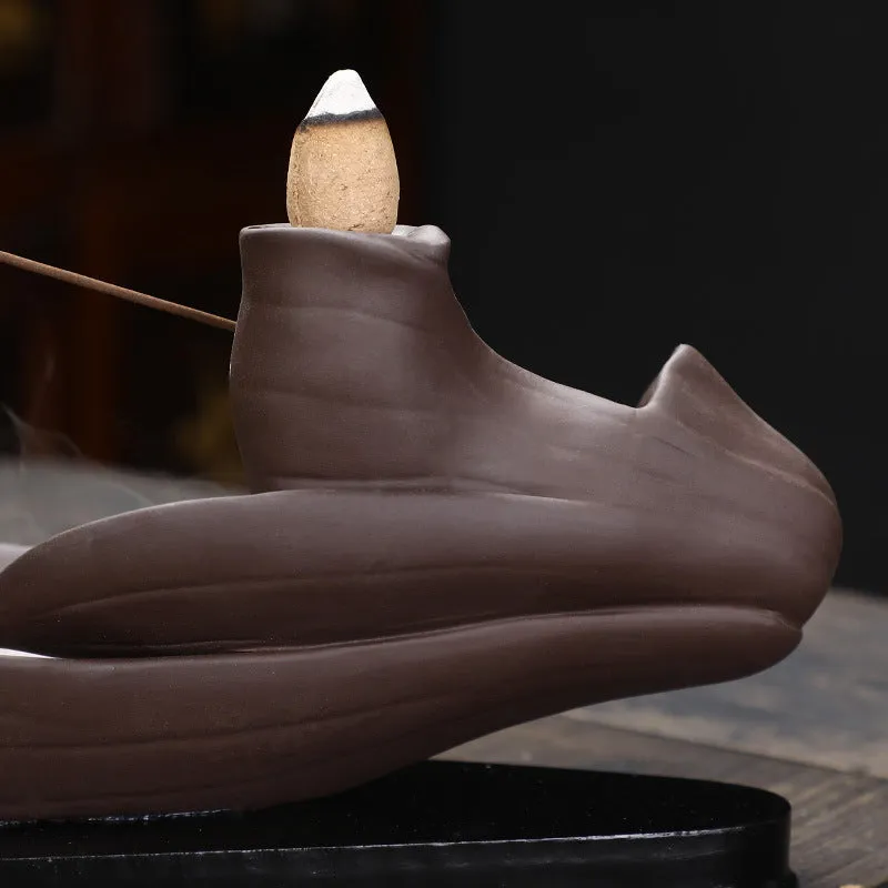 Brown purple sand backflow incense burner 21cm long on flat surface