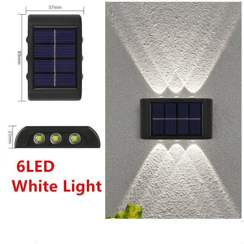 Black solar outdoor garden wall light with up and down glowing effect on a brick wall at night