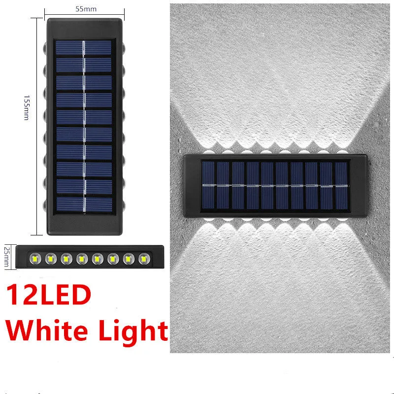 Black solar outdoor garden wall light with up and down glowing effect on a brick wall at night
