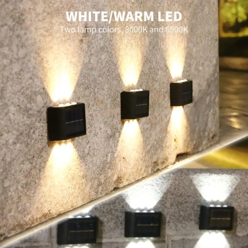 Black solar outdoor garden wall light with up and down glowing effect on a brick wall at night