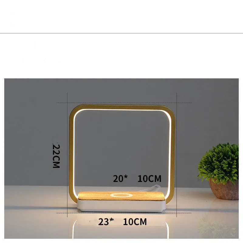 Modern white smart bedside lamp with touch control and USB cable on a wooden nightstand.