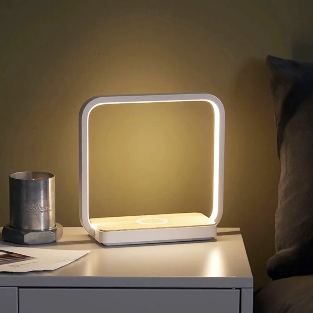 Modern white smart bedside lamp with touch control and USB cable on a wooden nightstand.