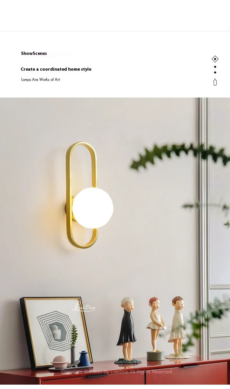 Minimalist wall-mounted lamp with clear glass bulb shade on a black iron sconce arm and backplate.