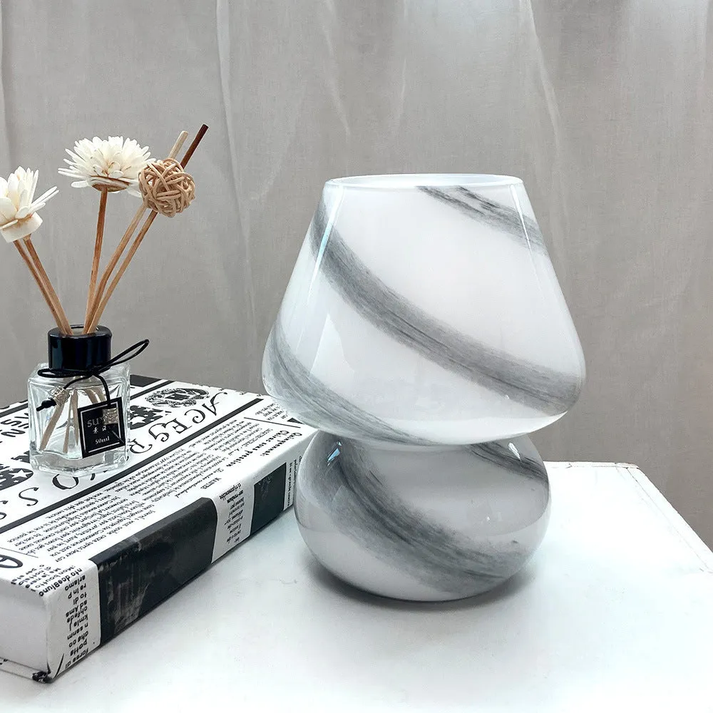 Handmade glass mushroom table lamp in Earth colour on a wooden bedside table with a soft glow
