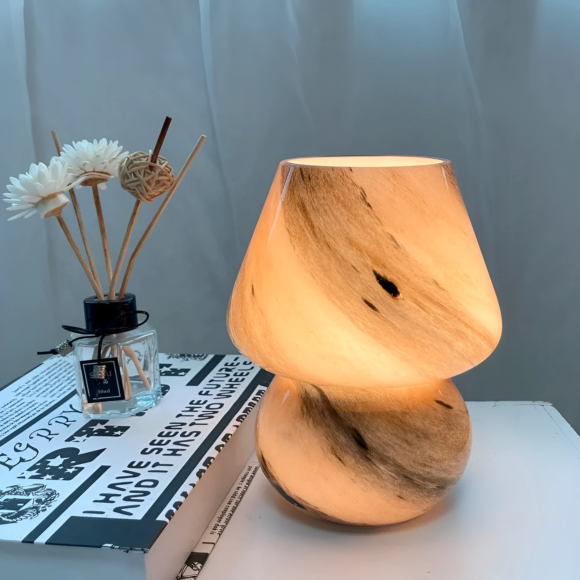 Handmade glass mushroom table lamp in Earth colour on a wooden bedside table with a soft glow
