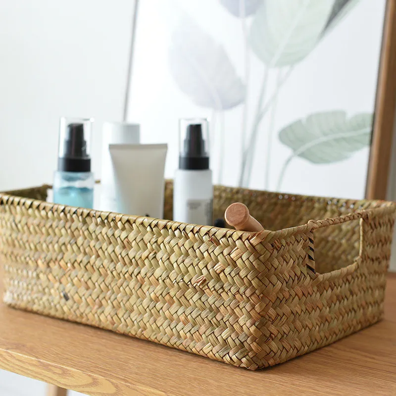 Handmade straw woven rectangular storage basket in natural grass fibre on a shelf