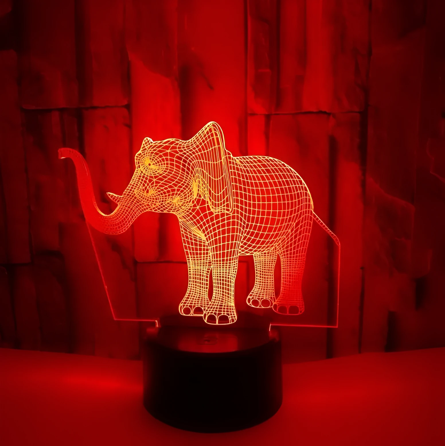 3D LED elephant touch lamp showing seven colour modes on a wooden desk