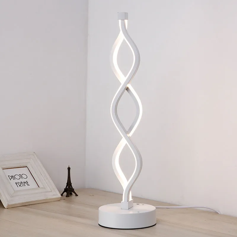 Modern LED desk lamp with aluminium metal body and acrylic mask, gold colour, on a desk