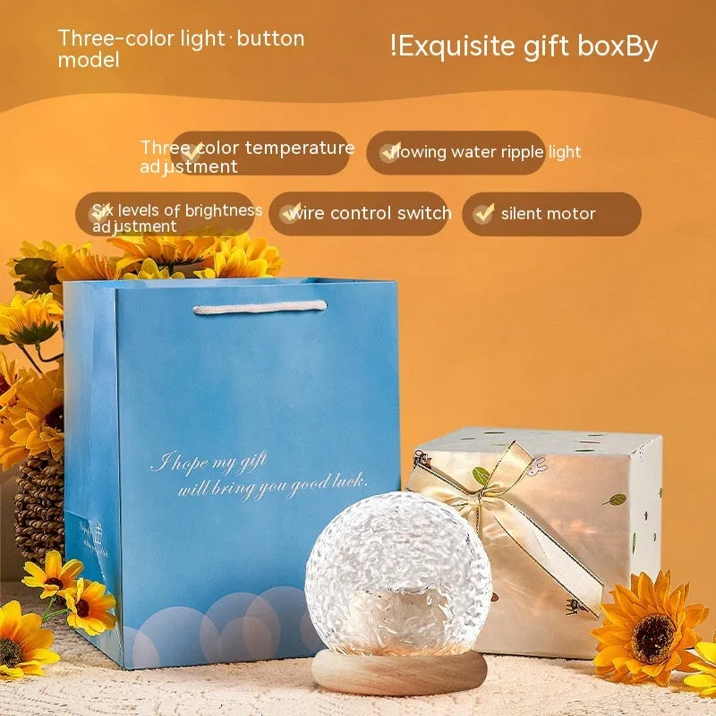 Projector night lamp with water ripple effect and remote control on a bedside table