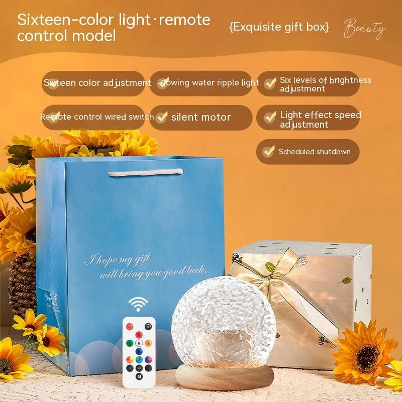 Projector night lamp with water ripple effect and remote control on a bedside table