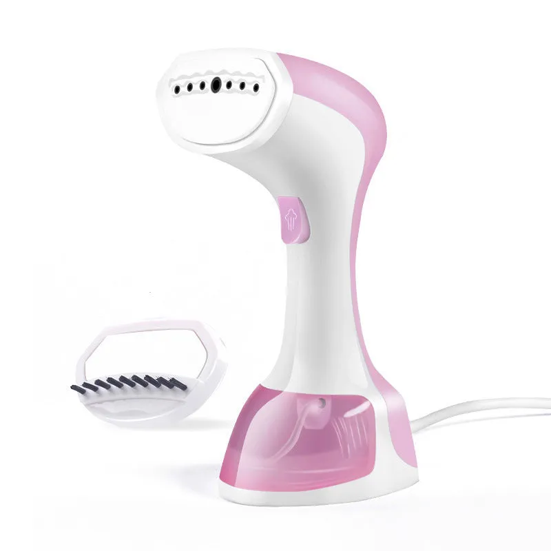 Mini portable handheld garment steamer 1200W in pink with water tank and brush on a wooden surface