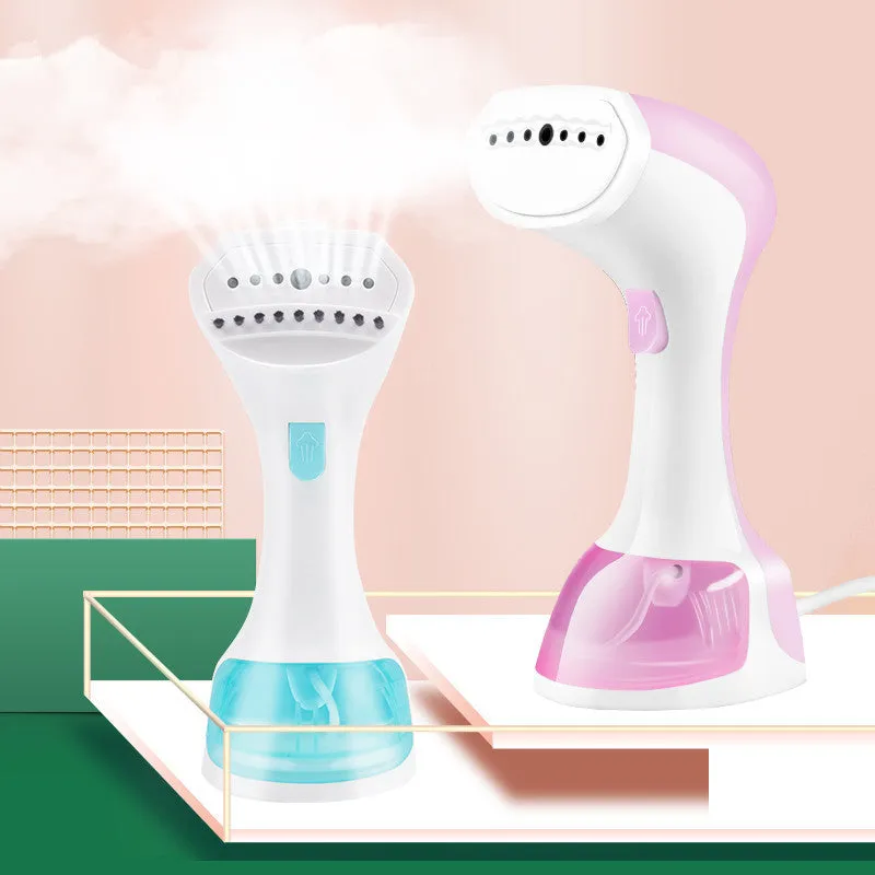 Mini portable handheld garment steamer 1200W in pink with water tank and brush on a wooden surface