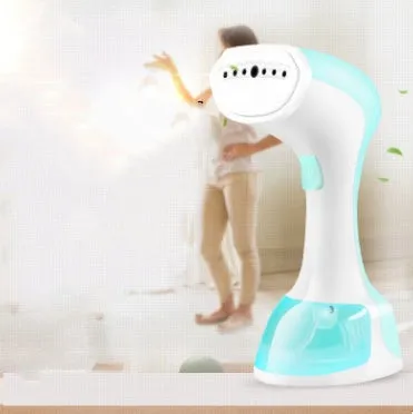 Mini portable handheld garment steamer 1200W in pink with water tank and brush on a wooden surface