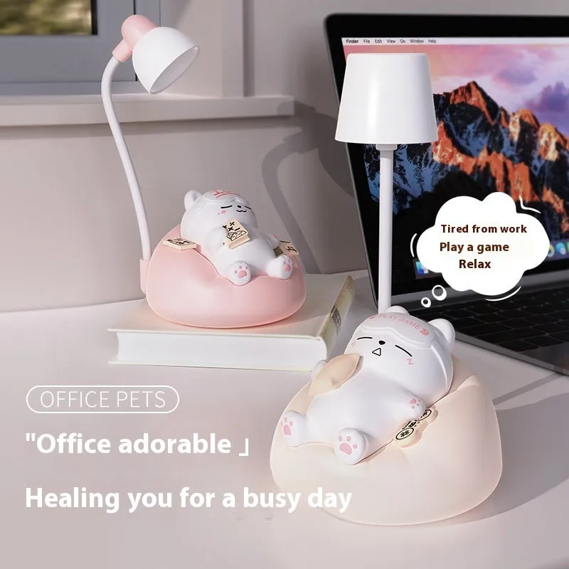 Sleeping cat shaped small night lamp in pink with USB charging cable on bedside table