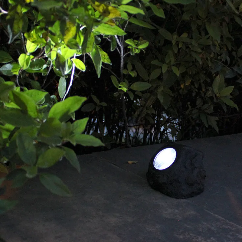 Black solar lamp with simulation stone exterior in outdoor garden setting, IP65 rated LED light