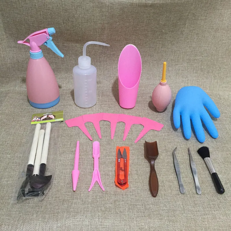 Succulent gardening tool set showing a small watering can, bucket, mini shovel, rake, tweezers, and scissors on a table.