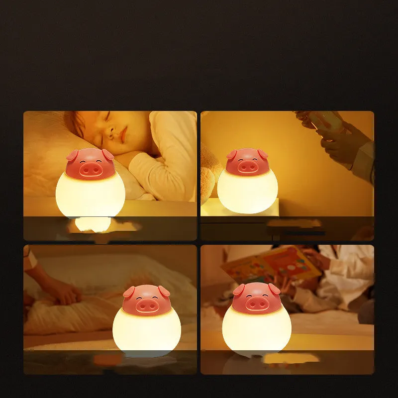 Pink pig silicone pat bedside lamp with USB LED light source on a table