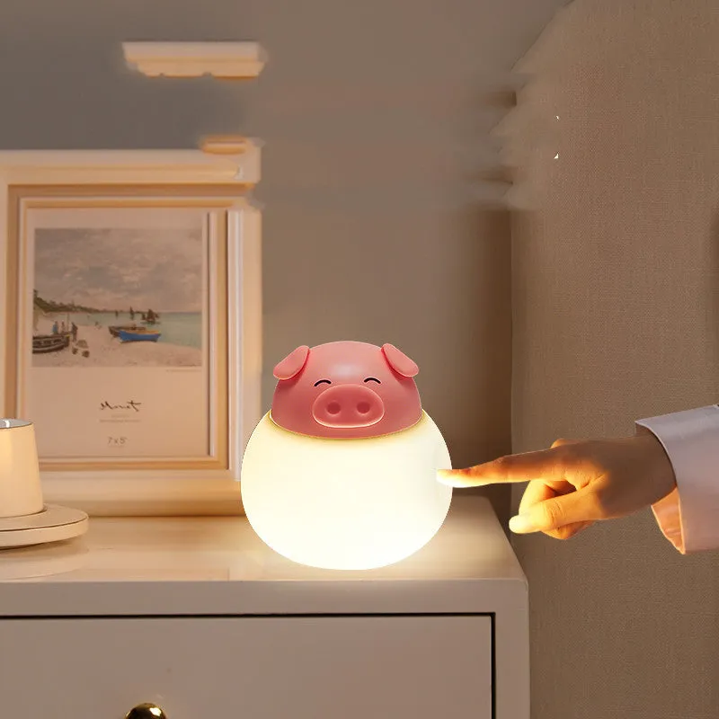 Pink pig silicone pat bedside lamp with USB LED light source on a table