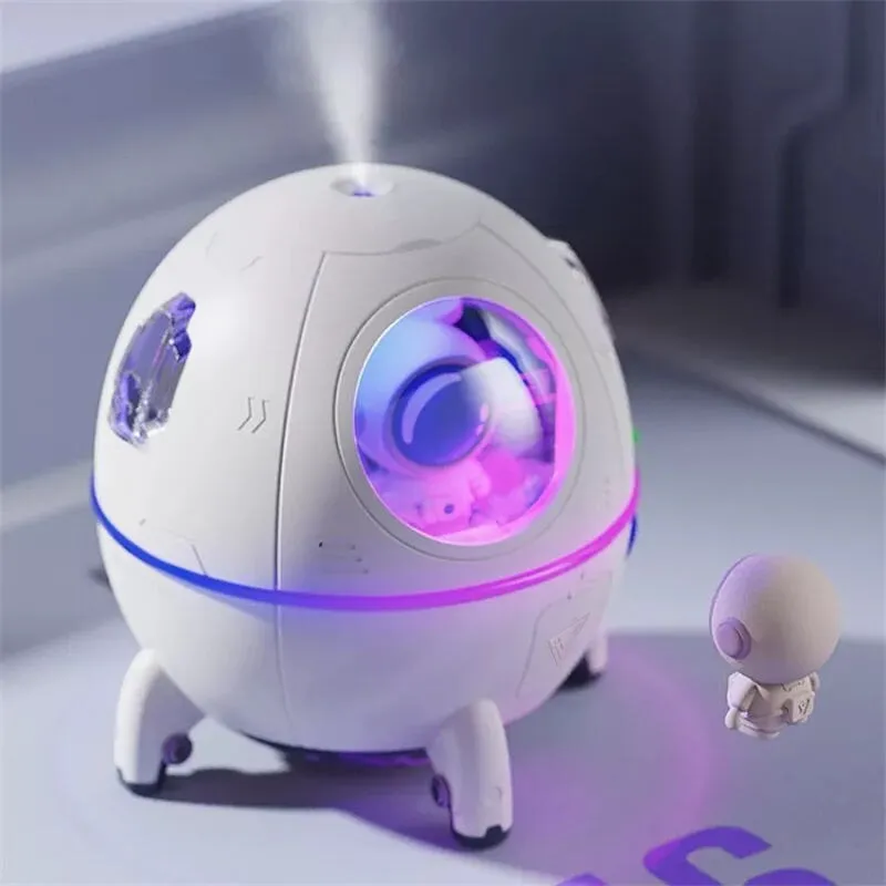 Purple astronaut space capsule USB humidifier with colourful LED lights on desktop
