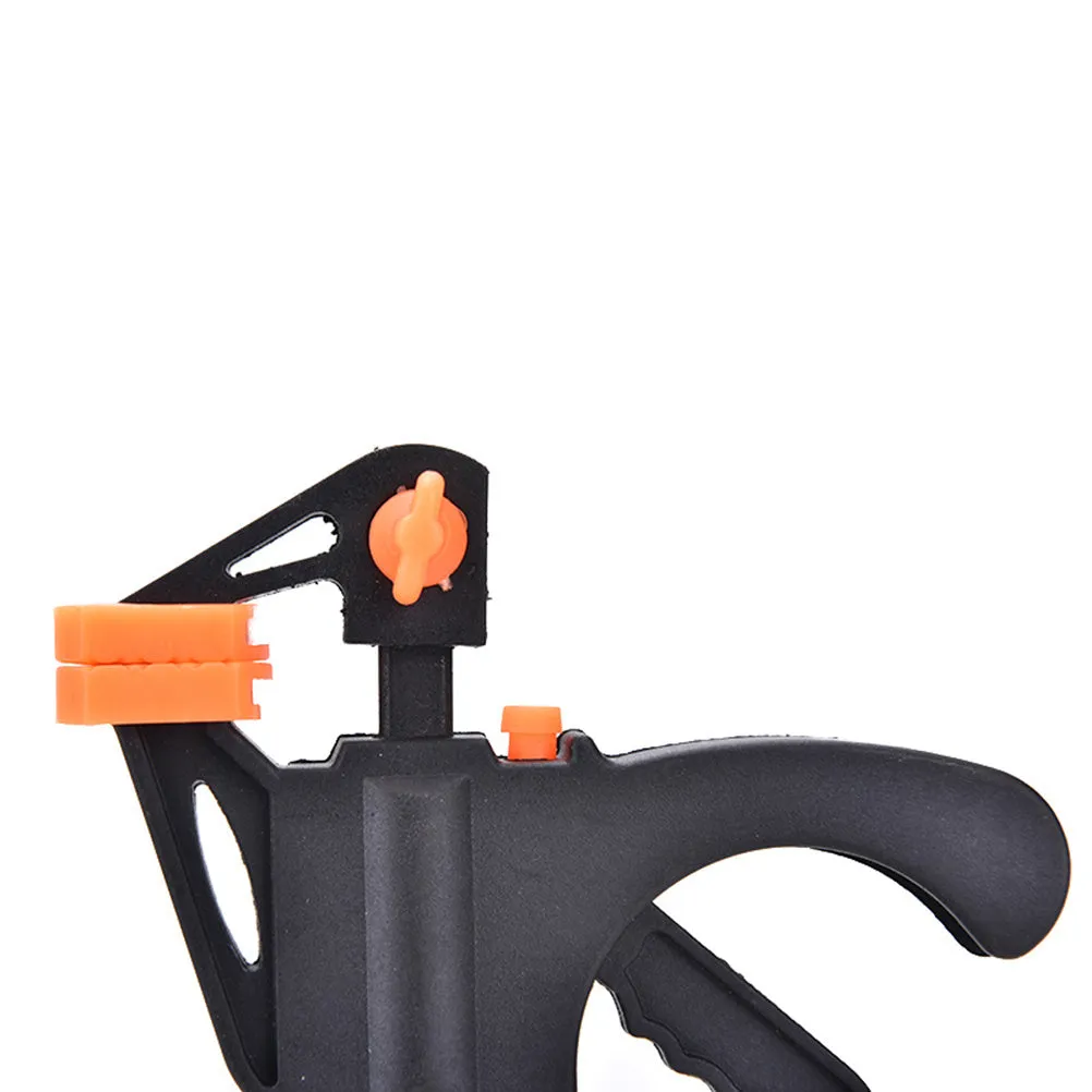 Black woodworking F clip 4 inch with plastic body and carbon steel rod on wooden board